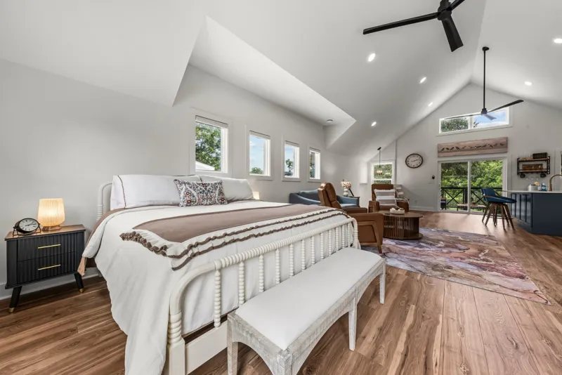 King bed in the open studio, with the living area and kitchen visible beyond