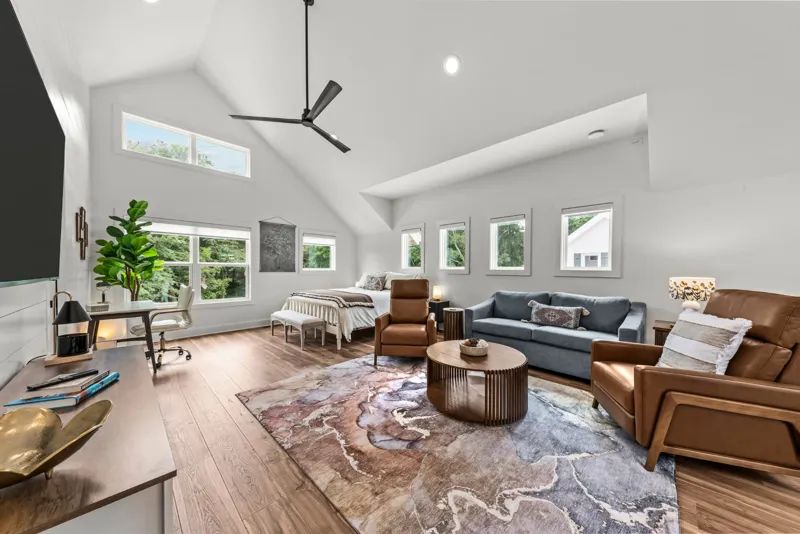 Open studio with vaulted ceiling, seating area, sofa, and the king bed in the same room